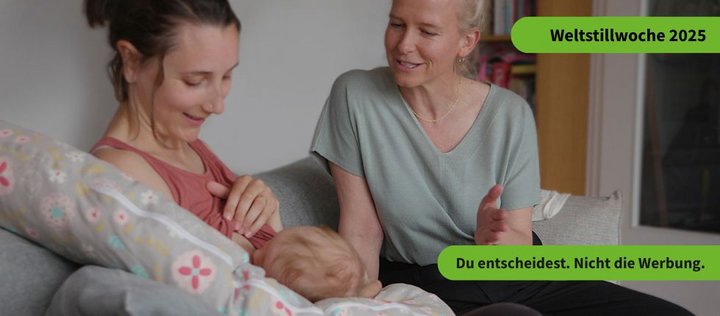Eine stillende Frau wird von einer Hebamme beraten. Auf dem Bild ist der Text " Weltstillwoche 2025" und "Du entscheidest. Nicht die Werbung" zu sehen.