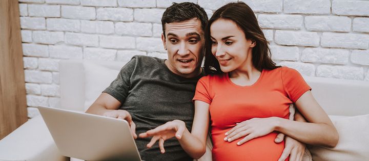 Schwangeres Paar mit Laptop