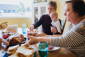 Großeltern mit Baby am Esstisch