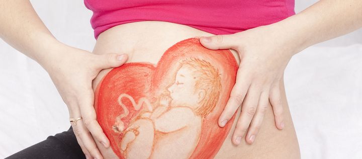 Herz und Foetus auf Schwangerenbauch gemalt