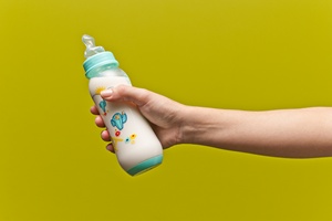 Hand hält Babyflasche