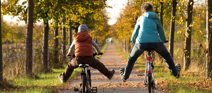 Kinder fahren Fahrrad im Herbst