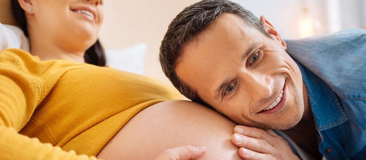 Mann horcht an schwangerem Bauch